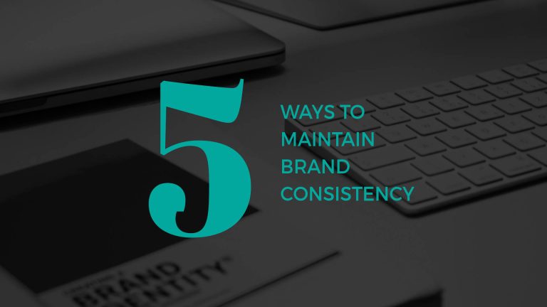 Graphic with the text "5 Ways to Maintain Brand Consistency" over a dark image of a desk with a laptop and branding documents.